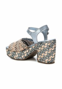 Sandalia de plataforma trenzada con una correa metálica azul y acentos trenzados en beige, con un tacón grueso y un diseño de punta abierta.