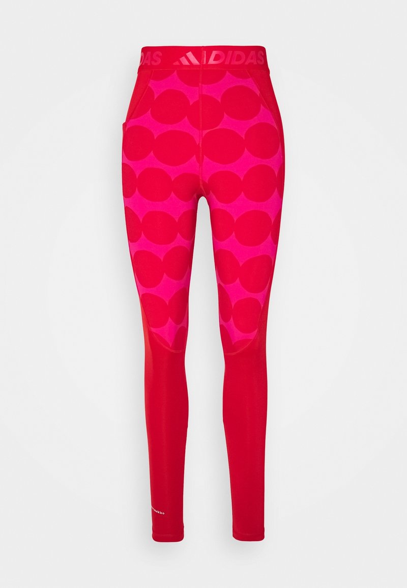 Leggings rouges avec un motif circulaire rose, fabriqués en matériau élastique. Présentent une taille rouge unie avec une marque en haut et des accents réfléchissants.