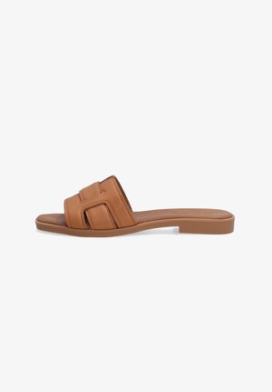 Sandales en cuir brun à enfiler avec un design à découpe carrée sur la bride et une semelle plate en caoutchouc. Texture lisse avec un style minimaliste.
