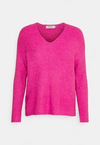 Lebendiger pinkfarbener, gerippter Strickpullover mit V-Ausschnitt, langen Ärmeln und einer lockeren Passform. Strukturiertem Stoff verleiht dem Design Tiefe.