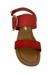 Sandalia de cuero rojo con dos correas y una hebilla circular plateada. La suela es de color marrón claro y presenta costuras visibles.