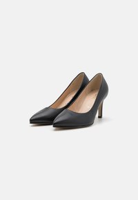 Svarta läderpumps med hög klack och spetsig tå-design. Har en slank silhuett och en 11,4 cm stilettklack.