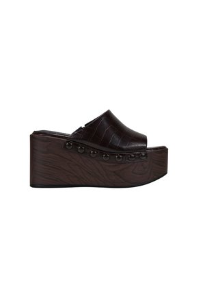 Sandalia de plataforma color marrón oscuro con puntera abierta, tacón de cuña con textura de madera y ribete con tachuelas a los lados.