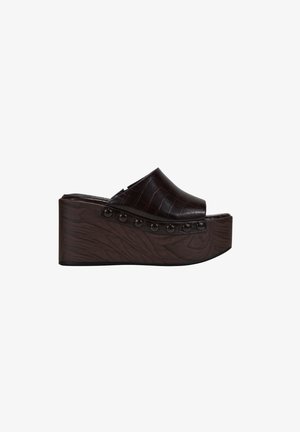 Sandalia de plataforma color marrón oscuro con puntera abierta, tacón de cuña con textura de madera y ribete con tachuelas a los lados.