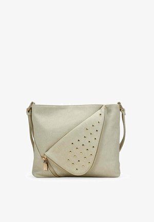 Bolso bandolera beige con tachuelas en tono dorado sobre una solapa doblada y un detalle de cremallera, con una correa ajustable para el hombro.