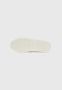 White sneaker sole with textured rubber for grip, featuring a rounded shape and a flat design. Minimalistic with no visible branding.