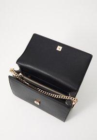 Borsa a tracolla nera in pelle con finitura testurizzata, catena dorata e chiusura a scatto. L'interno presenta un comparto con cerniera e un design minimalista.
