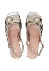 Open-toe metallic gold sandals with a cutout design, featuring a square metallic accent and a large round embellishment on the upper.
