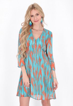 Kleid mit kurzen Ärmeln in aquafarbenem und orangefarbenem abstraktem Muster, mit V-Ausschnitt und gerafftem Taillenbereich, fließender Röckenstruktur und leichtem Stoff.