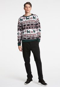 Sweater de malha com padrões de festa em branco, vermelho e verde, incluindo renas e designs geométricos; gola redonda, punhos e bainha canelados.