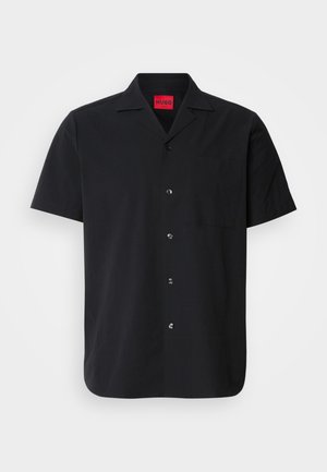 Kortermet svart skjorte laget av lett stoff, med vanlig krage, en lomme foran og seks runde knapper langs knappenstanden.