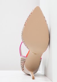 Beige high-heeled shoe with mesh cutouts and pink accents. Pointed toe and slender heel, smooth sole with subtle tread. Gold logo detail.