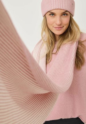 Rosa stickad mössa och scarf med ribbad textur. Tröjan har en solid mjuk rosa färg. Tyget ser varmt och mysigt ut.