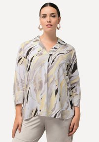 Blusa leggera con un motivo astratto multicolore in grigio, crema e giallo, dotata di colletto e maniche a tre quarti.