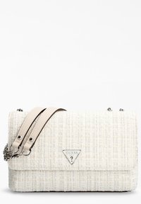 Sac à main en tissu tweed avec un extérieur texturé de couleur crème clair. Il présente un logo en métal argenté, des doubles poignées en cuir et un accent en chaîne.