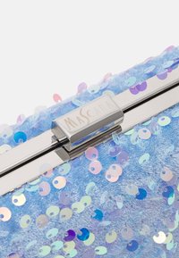 Glittrig blå clutch tillverkad av mjukt material, prydd med flerfärgade paljetter och ett silverfärgat metallspänne med texten "Mascara."