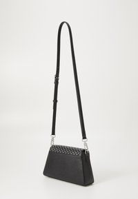 Black faux leather crossbody bag with a triangular shape, studded top, and adjustable strap. Features silver hardware and a textured design.