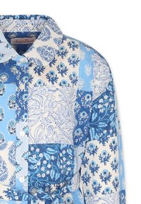 Vestito blu e bianco con colletto, decorato con motivi floreali che presentano una combinazione di motivi grandi e piccoli, bottoni davanti e vita regolabile con una fettuccia.