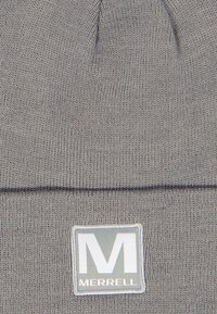 Grå strik beanie hat med en foldet manchet. Har et rektangulært mærke med et hvidt "M" logo og "MERRELL" tekst. Blødt, struktureret stof.