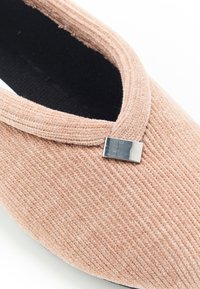 Scarpa slip-on in corduroy rosa con una parte superiore testurizzata, caratterizzata da un elegante accento argento e una fodera interna nera. Design con punta arrotondata.