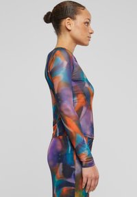 T-shirt à manches longues en tissu extensible avec un motif abstrait multicolore aux teintes de bleu, orange et violet. Design ajusté.