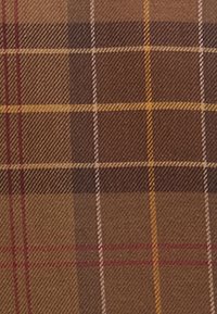 Hnědé kostkované tkaniny s kostkovaným vzorem, které se skládají z tmavohnědých, světlehnědých a žlutých pruhů, což dodává texturovaný vzhled.