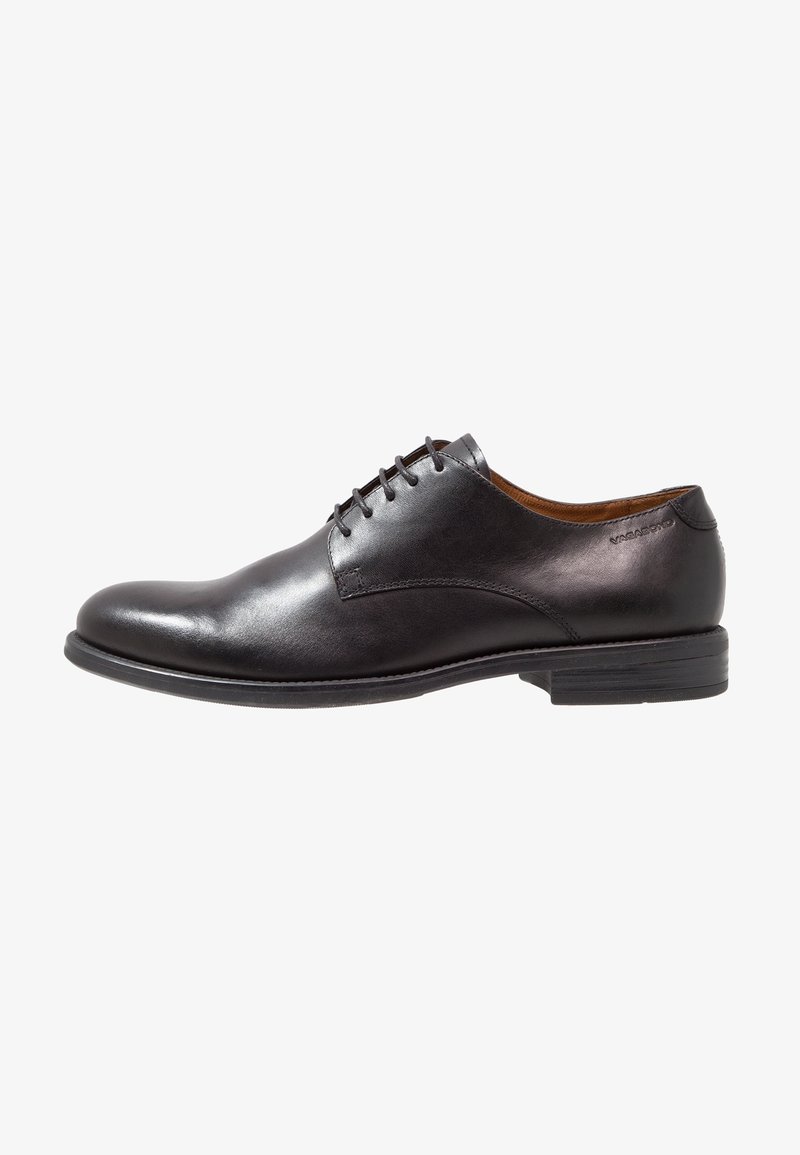 Chaussure habillée à lacets pour homme en cuir noir à finition lisse et petit talon empilé, vue de côté sur fond blanc.