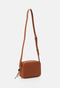 Brown leather crossbody bag with a rectangular shape, textured surface, adjustable strap, and a zip closure. Gold-tone hardware accent.