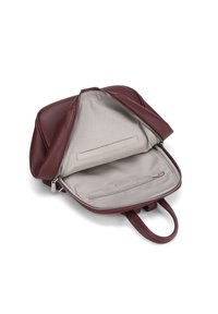 Sac à dos en cuir bordeaux avec fermeture éclair. L'intérieur présente une doublure beige, une poche plate et un compartiment zippé pour l'organisation.