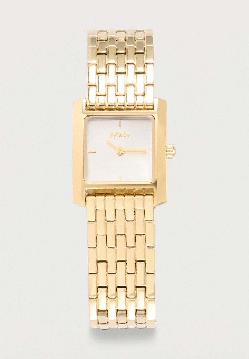Χρυσού τόνου ορθογώνιο ρολόι χειρός με συνδεδεμένο μεταλλικό βραχιόλι, μινιμαλιστικό καντράν που δείχνει την ώρα στις 10:15 και το λογότυπο "BOSS" στο καντράν.
