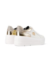 Sneakers bianchi con una suola bianca spessa, caratterizzati da accentuazioni dorate e glitterate sul tallone e una parte superiore in pelle liscia. Dettaglio in metallo dorato incluso.