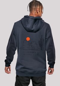 Navy blue hoodie with a front kangaroo pocket, featuring a graphic of a desert landscape and sunset on the back.