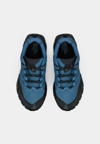 Μπλε παπούτσια πεζοπορίας με μαύρες λεπτομέρειες· ανθεκτικό επάνω μέρος από ύφασμα, ενισχυμένη μύτη και υφασμένο καουτσούκ στην σόλα· έξι ζευγάρια μαύρα κορδόνια.