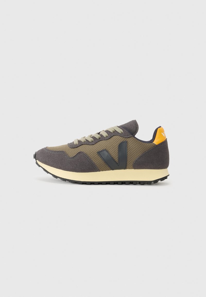 Laufschuh mit einem dunkelgrauen und olivgrünen Obermaterial, kontrastierendem schwarzen Logo, leichtem Design, Gummisohle und orangen Akzenten an der Ferse.