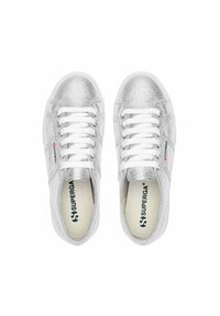 Sneakers metallizzate argento con lacci bianchi, suole in gomma e texture liscia. Presentano il logo Superga sul lato e nella soletta.