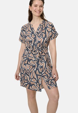 Mujer sonriente que lleva un vestido de manga corta con botones al frente, estampado abstracto en tonos beige, azul marino y marrón, cinturón atado y abertura lateral.