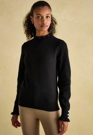 Black sweater featuring a ribbed neckline and cuffs, textured fabric, and decorative buttons on the sleeves. Smooth fit with a warm appearance.