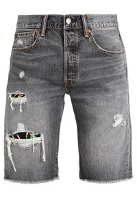 Pantalones cortos de mezclilla gris con agujeros desgastados que revelan parches de tela floral por debajo, con dobladillos deshilachados y el clásico estilo de cinco bolsillos.