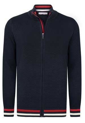 Cardigan navy con zip realizzato in tessuto a maglia texture. Presenta un colletto alto con dettagli a strisce rosso, bianco e blu su polsini e orlo.