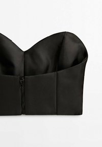 Haut bustier noir sans bretelles avec bonnets structurés et fermeture éclair avant sur fond blanc uni.