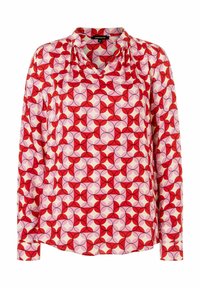 Lange mouwen blouse in rode, roze en crèmekleurige stof. Heeft een geometrisch patroon met cirkels en bloemblaadjes. V-halslijn en geplooide schouderdetails.