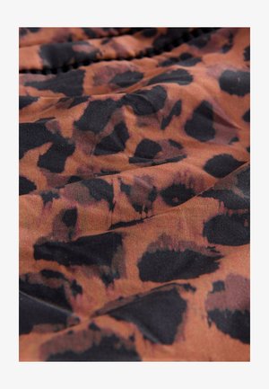 Tissu imprimé léopard affichant un mélange de nuances orange, marron et noir avec une texture douce et un léger éclat, présentant des tailles de motifs variées.