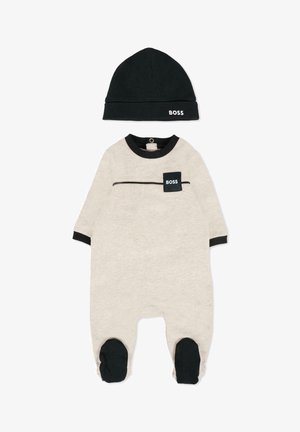 Romper per bebé in cotone beige con dettagli neri, dotato di una tasca con il logo "BOSS", maniche lunghe e berretto abbinato nero.