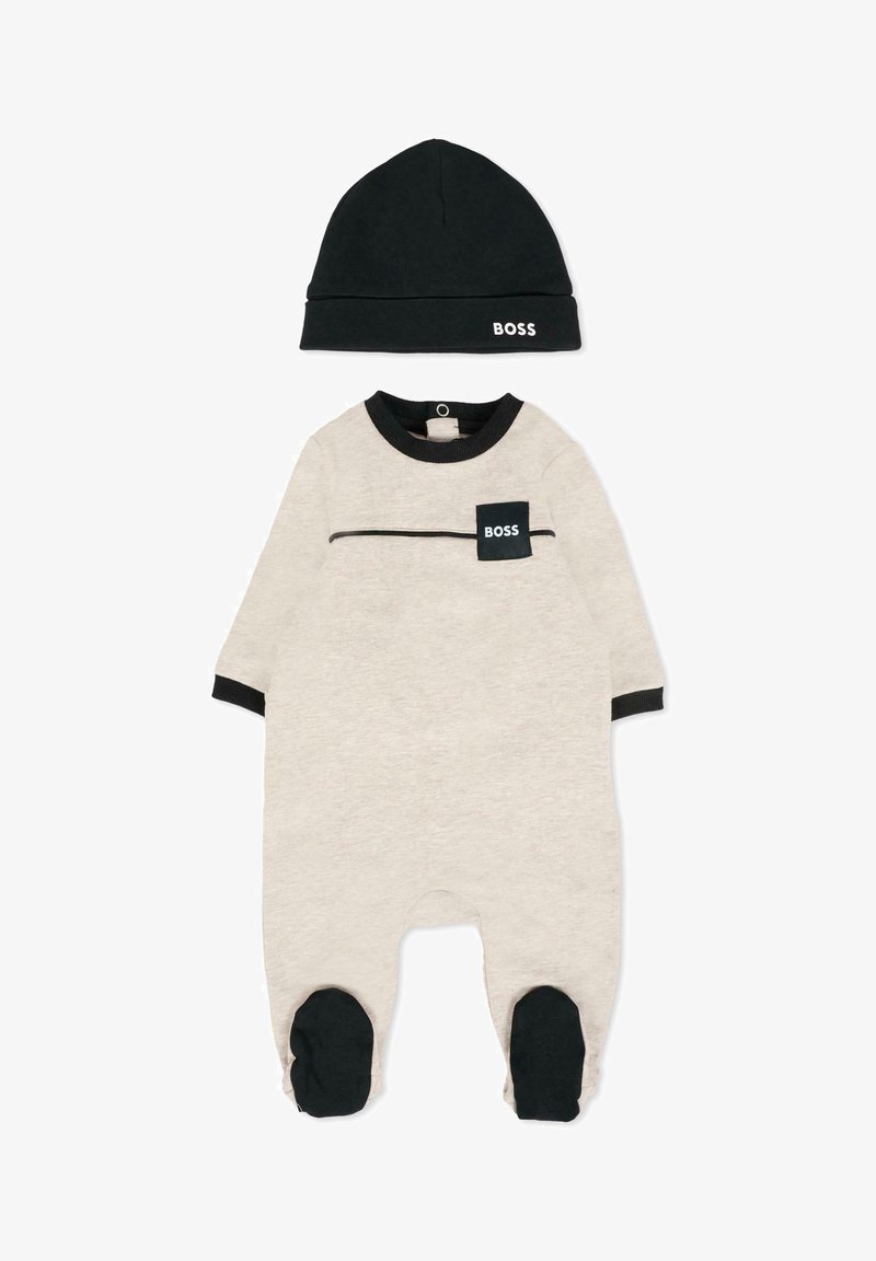 Bawełniany kombinezon dla niemowląt w kolorze beżowym z czarnymi akcentami, z kieszonką z logo "BOSS", z długimi rękawami oraz pasującą czarną czapką.