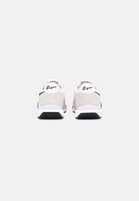 White and grey athletic shoes with a suede upper, black accents, and rubber sole. Features a logo on the heel and a padded collar.