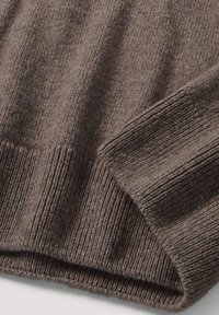 Dunkelbrauner Strickpullover mit strukturiertem Rippenmuster. Mit umgeschlagenem Saum und glattem Stoff, der weiches, warmes Material zur Schau stellt.