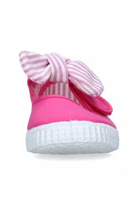Scarpa da ginnastica rosa con suola in gomma bianca texturizzata, caratterizzata da un grande fiocco a righe davanti e una parte superiore morbida e liscia.