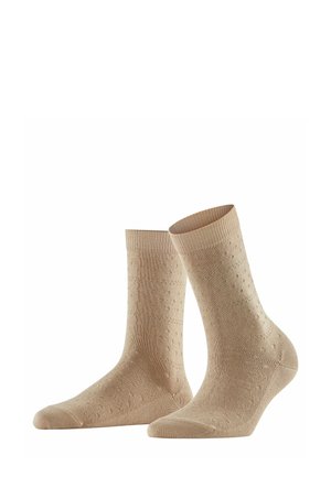 Beige Socken aus strukturiertem Material mit einem subtilen Punktmuster, gerippten Bündchen und einer glatten Zehenpartie.