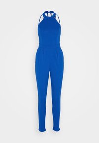 Un jumpsuit bleu avec un col montant, des fines bretelles et des jambes fuselées. Fabriqué dans un tissu lisse et extensible ; il présente une taille cintrée et des plis.