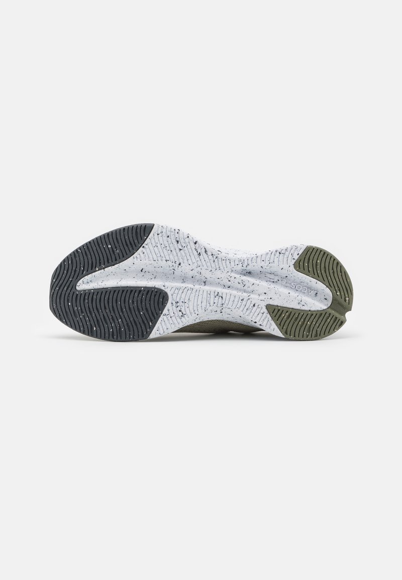 Suela de zapato con una base blanca texturizada y acentos en negro y verde oliva. Las ranuras notables mejoran la adherencia y la tracción.